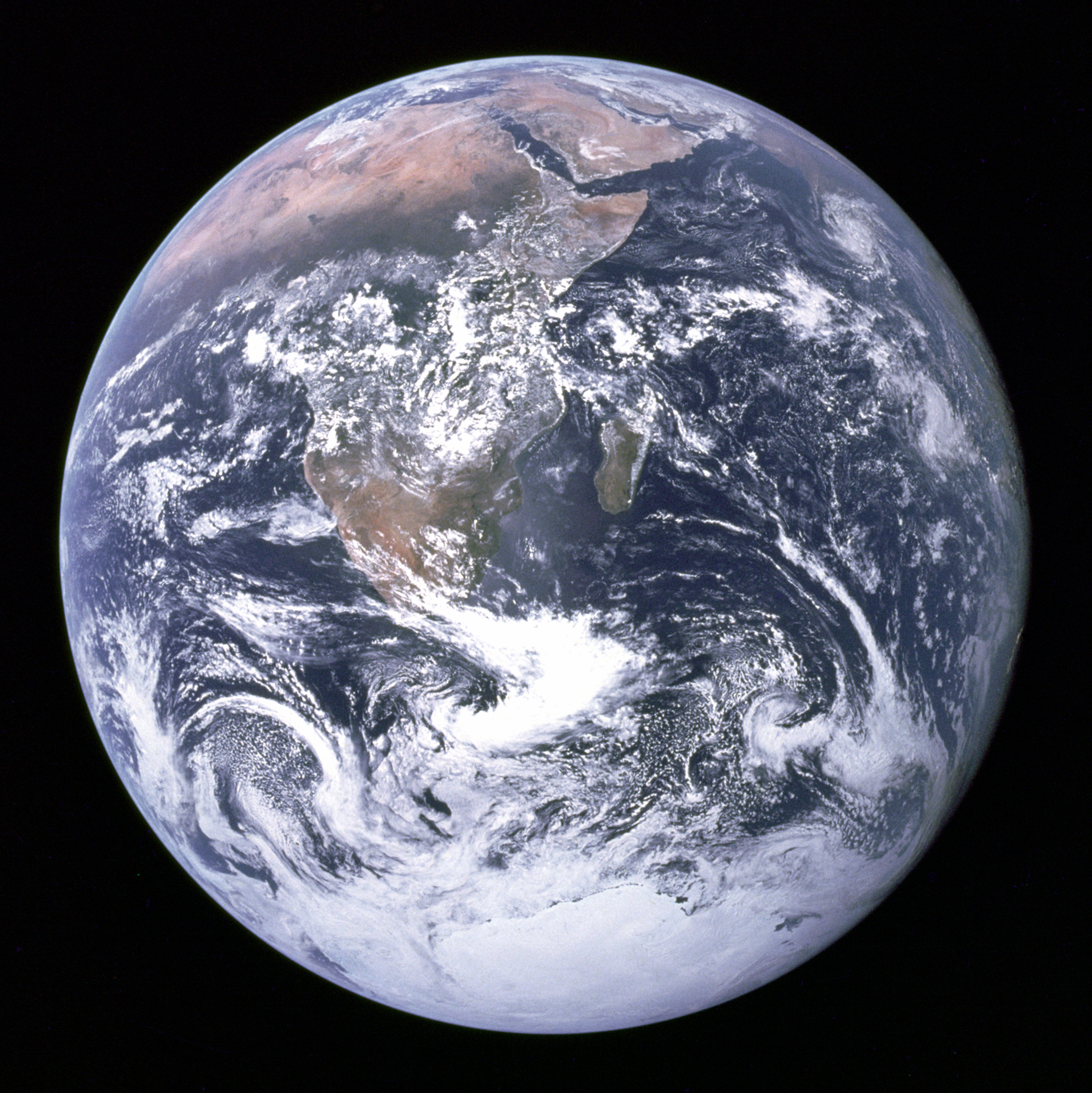 A photograph of the whole Earth from space, very nearly spherical but slightly flattened.