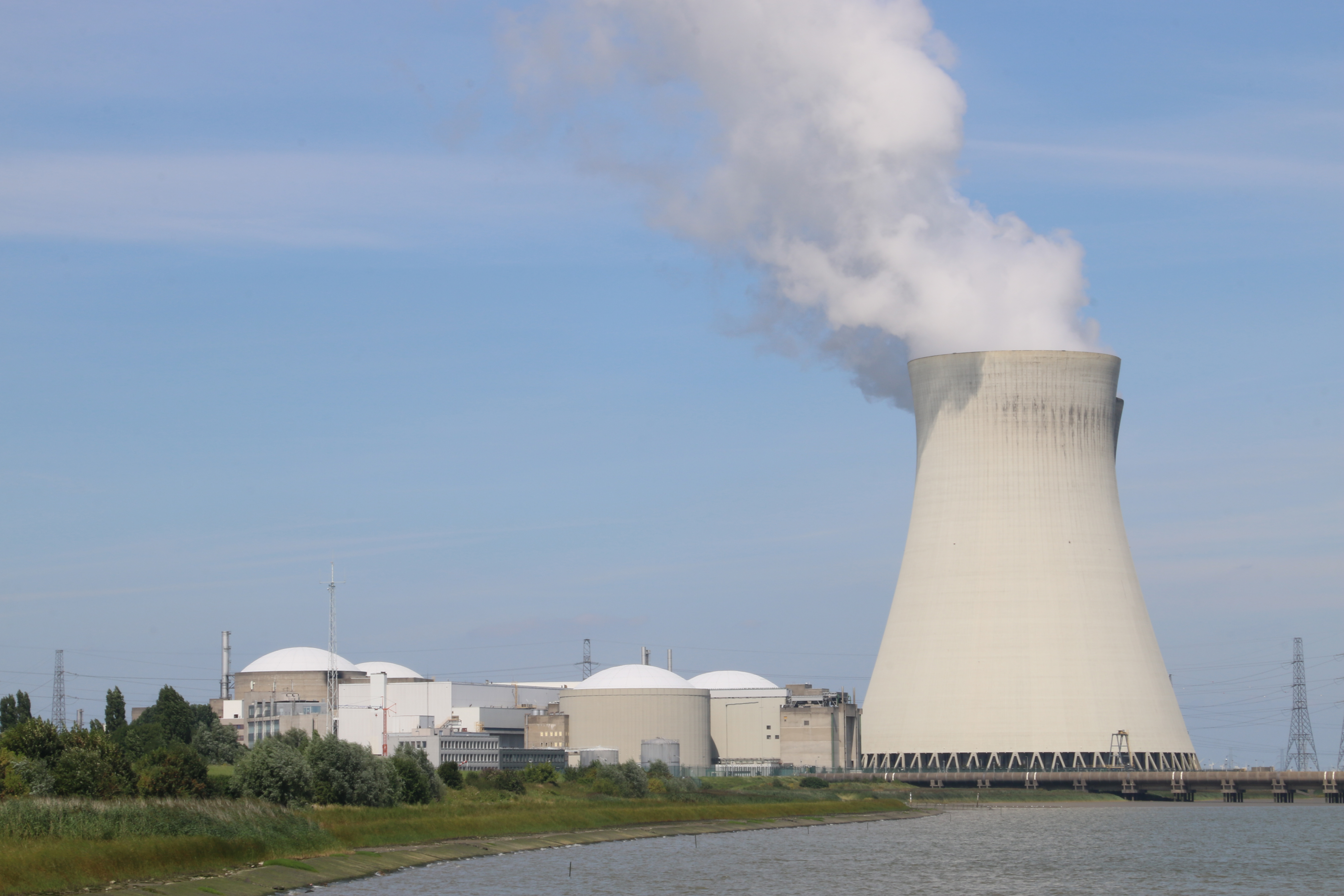 A tall concrete cooling tower that narrows to a waist in the middle and flares out at the top and bottom.